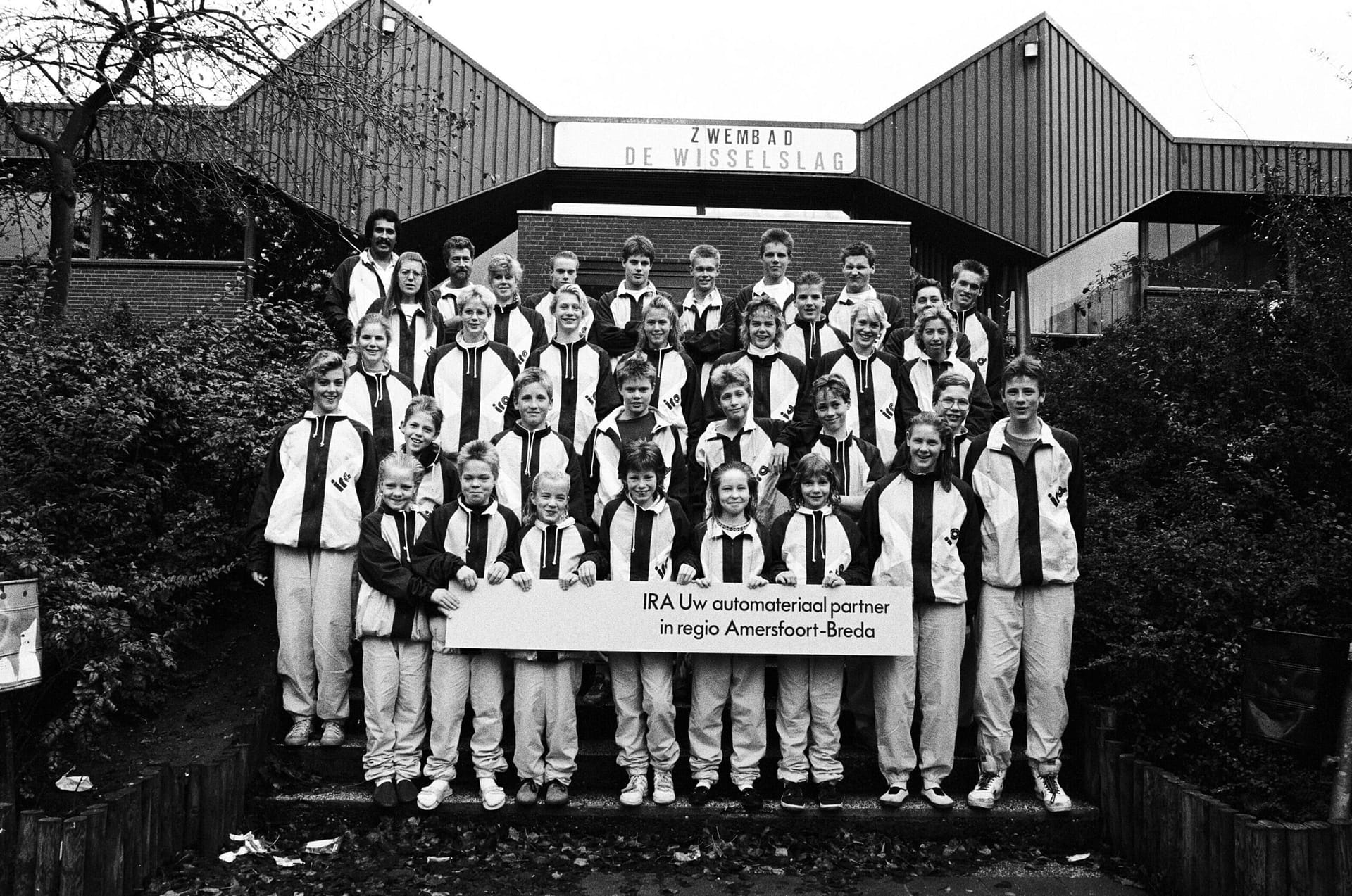 Groepsportret van zwemploeg De Wisselslag, voor het zwembad 1989 Groepsportret van zwemploeg De Wisselslag, voor het zwembad 1989