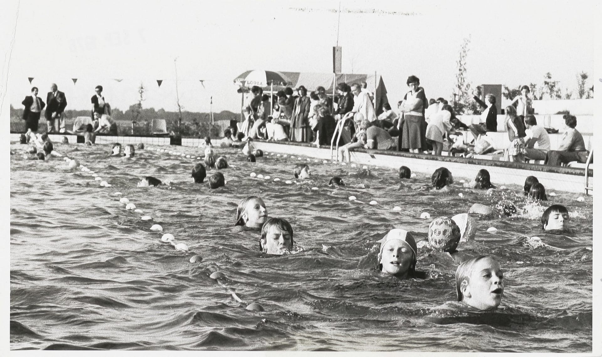 Kinderen zwemmen in het buitenbad tijdens de Zwemvierdaagse in zwembad De Wisselslag Kinderen zwemmen in het buitenbad tijdens de Zwemvierdaagse in zwembad De Wisselslag